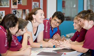 Students and teacher sitting around a table